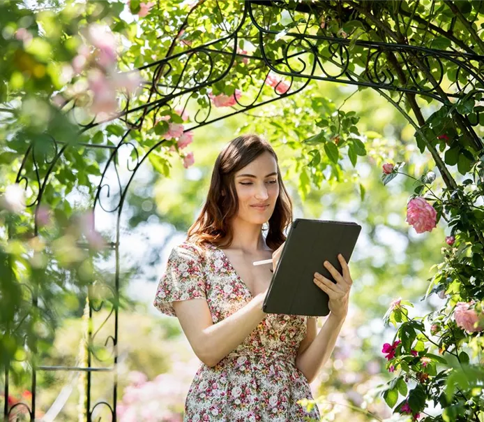 Frau mit Tablet im Garten